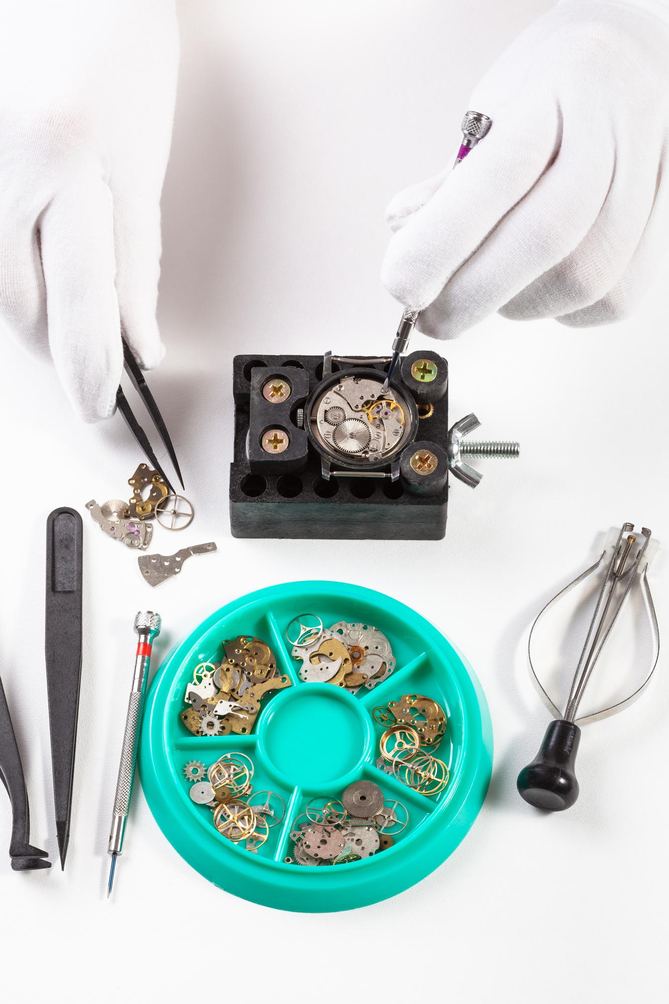 Interno del laboratorio orologiero con strumenti disposti su un banco grigio